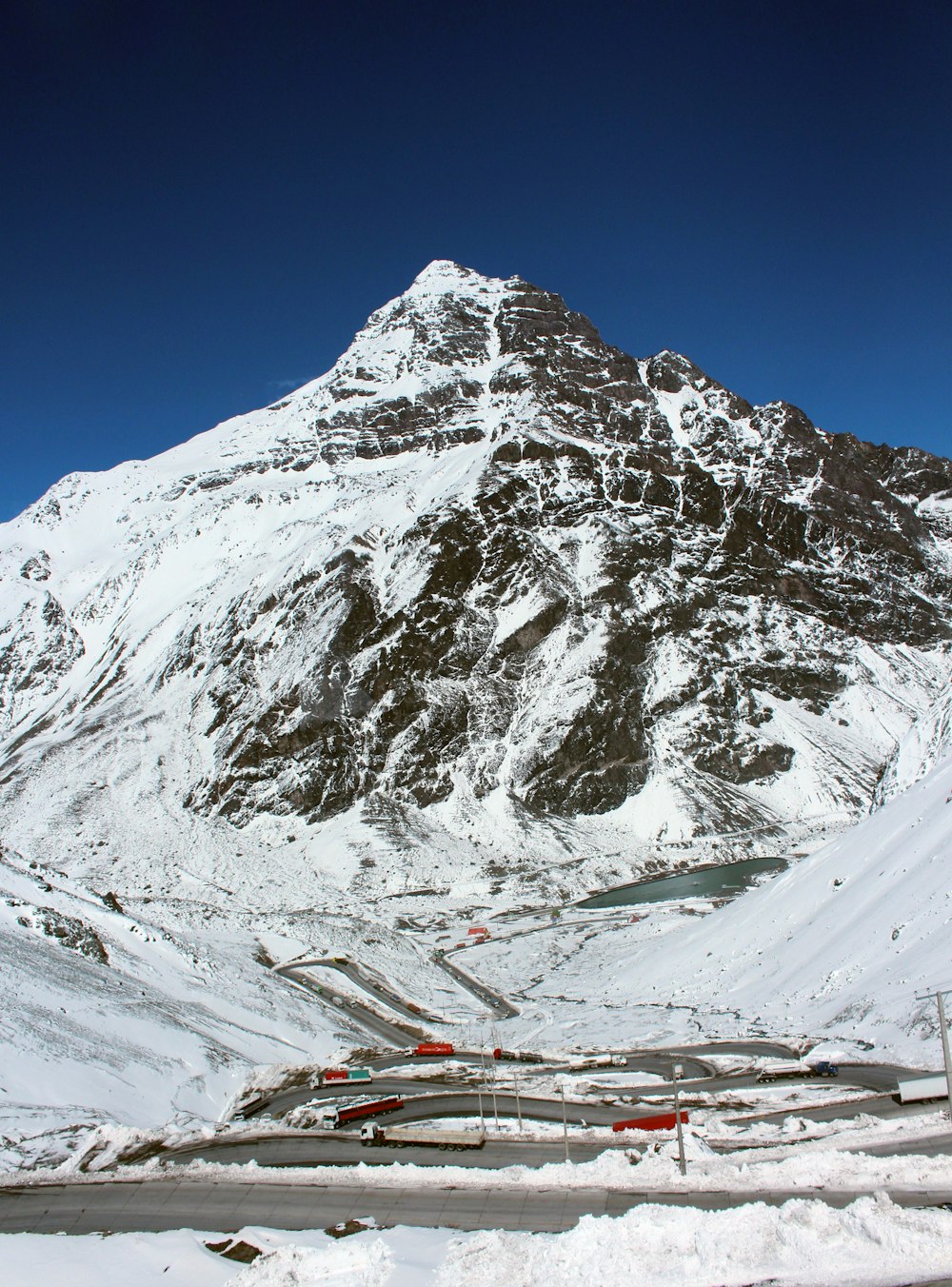 a snow covered mountain with a road in front of it