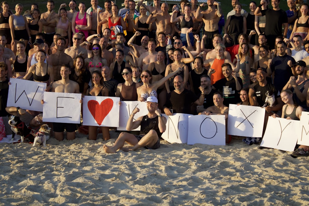 a group of people sitting on top of a sandy beach