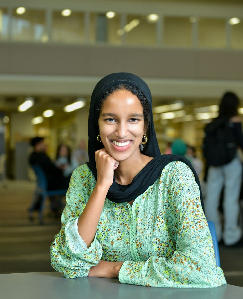 a woman sitting at a table with a smile on her face