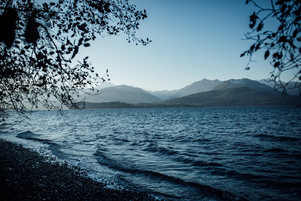 a body of water with mountains in the background