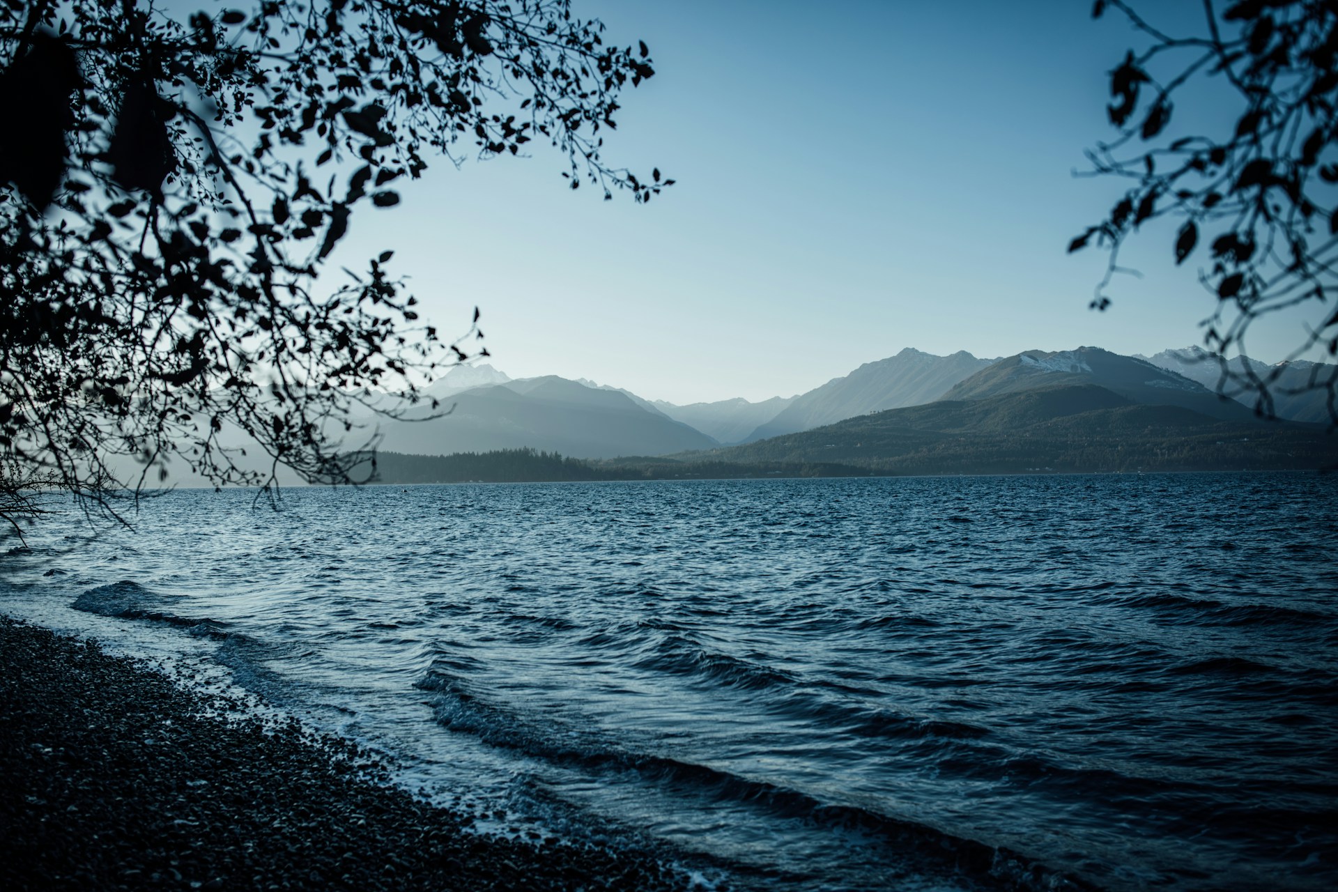a body of water with mountains in the background