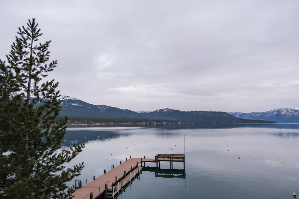 a dock on a lake with mountains in the background