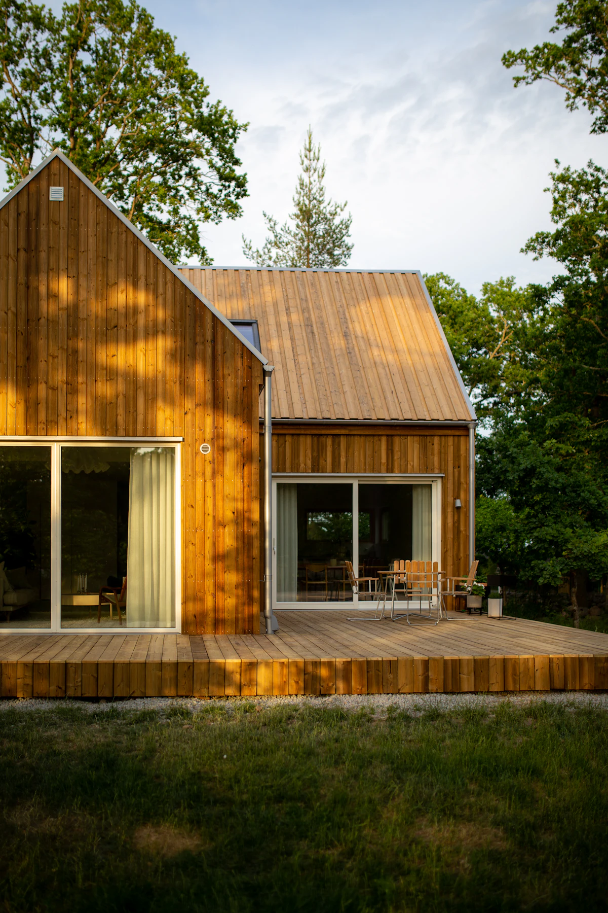 Moderne trehus med terrasse i skogkanten