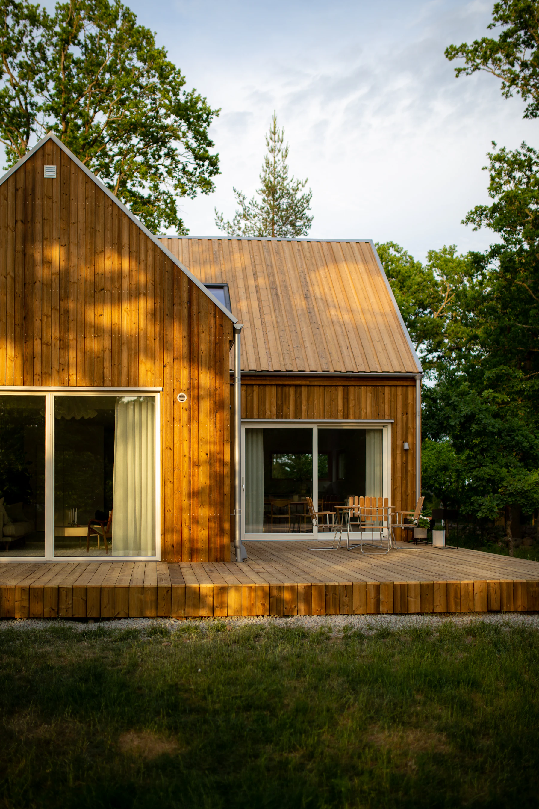 Moderne trehus med terrasse i skogkanten