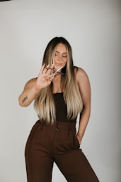 a woman in a brown jumpsuit smoking a cigarette