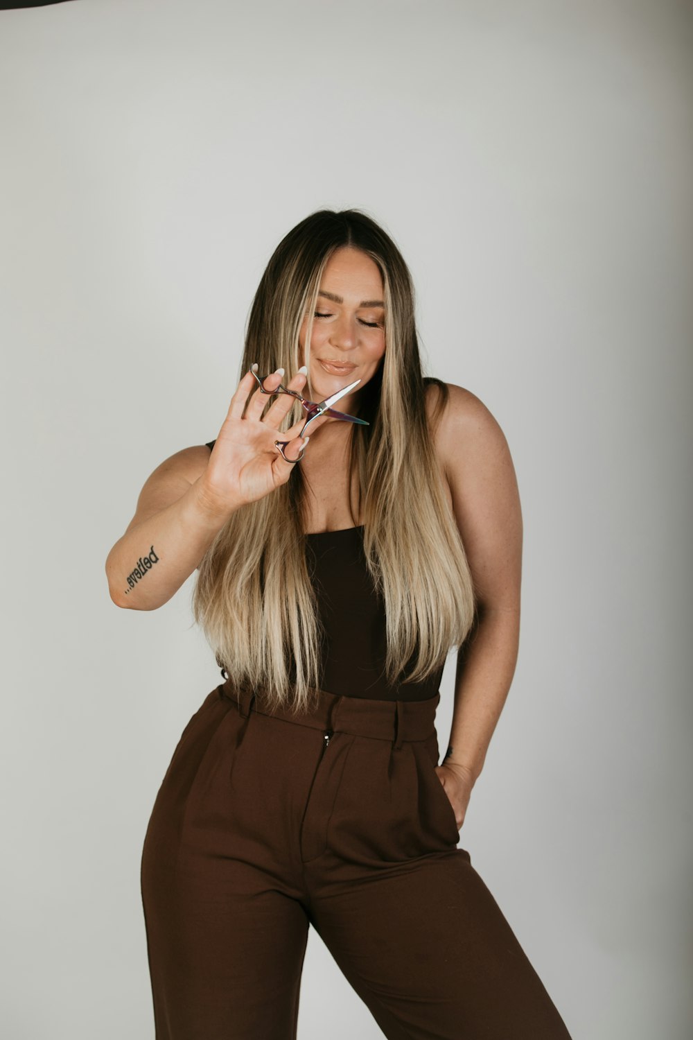 a woman in a brown jumpsuit smoking a cigarette