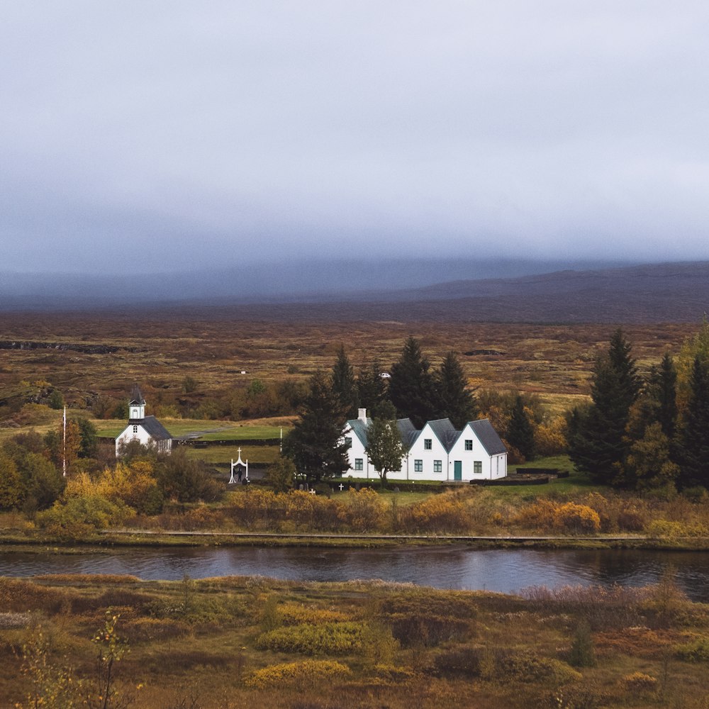 a white house sitting on top of a lush green field