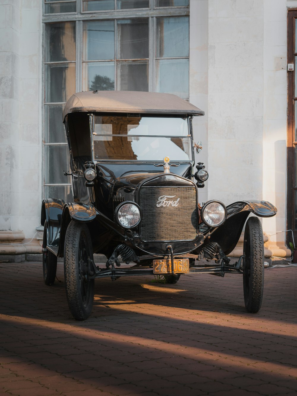 an old car is parked in front of a building