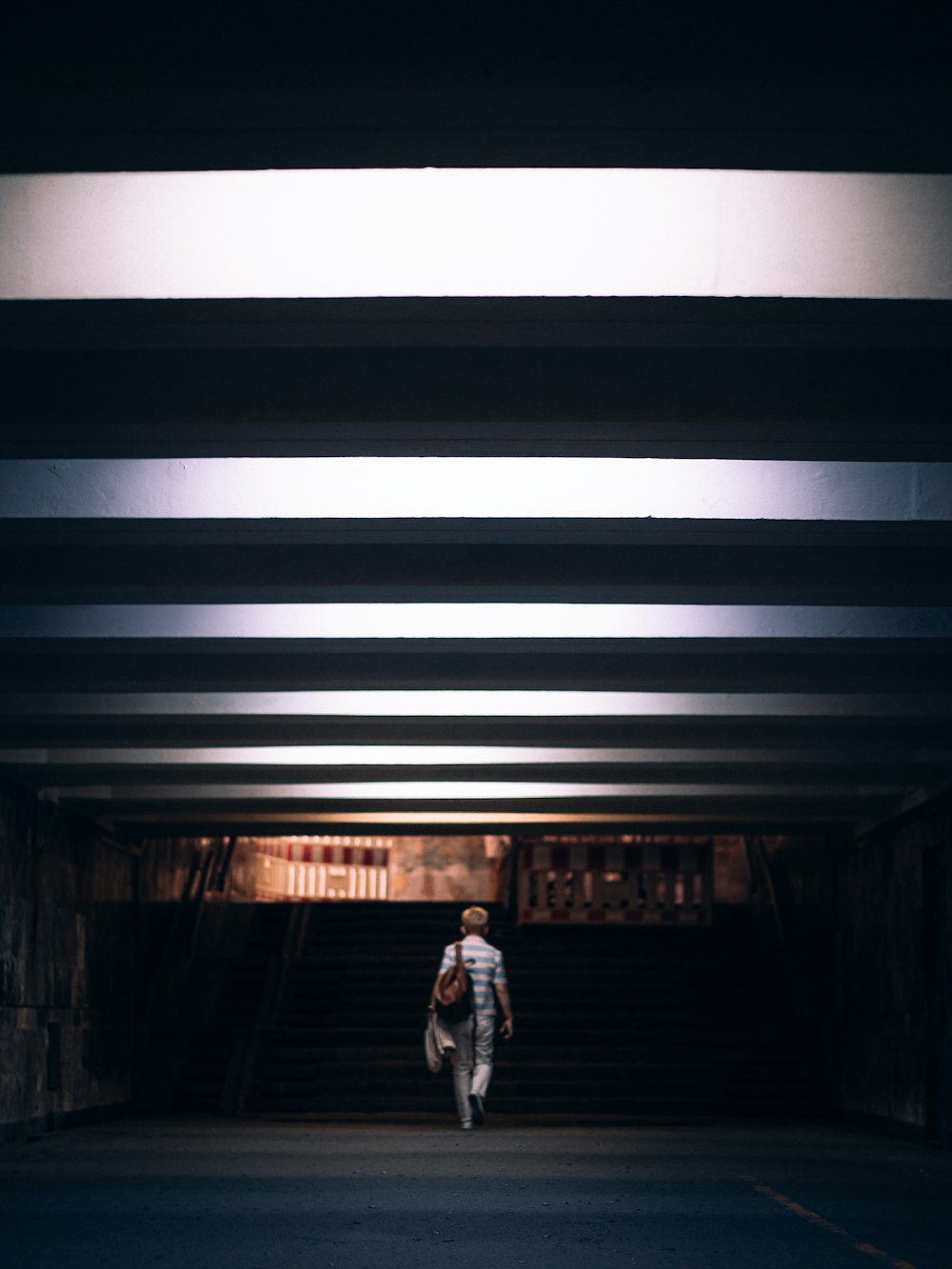 a person walking in a tunnel with a backpack