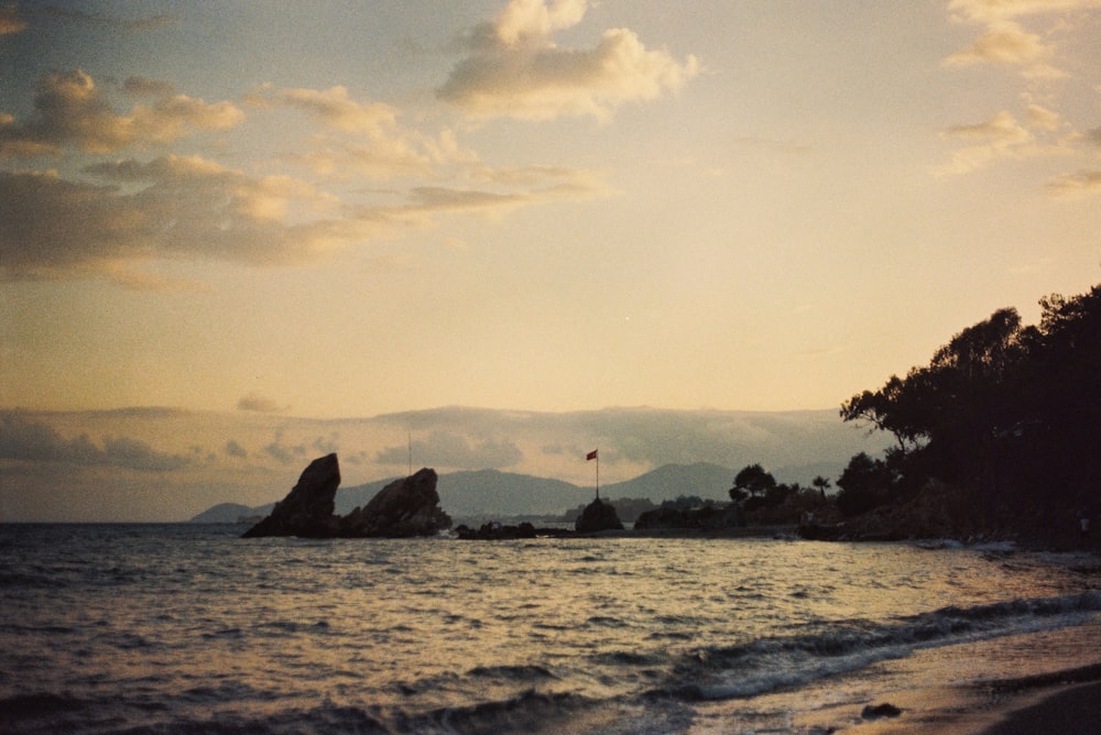 a view of a beach at sunset with waves coming in