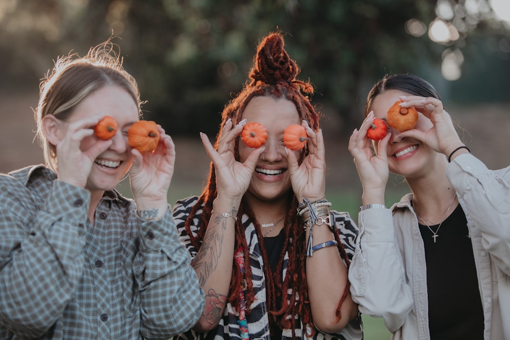 un gruppo di donne che tengono le arance agli occhi