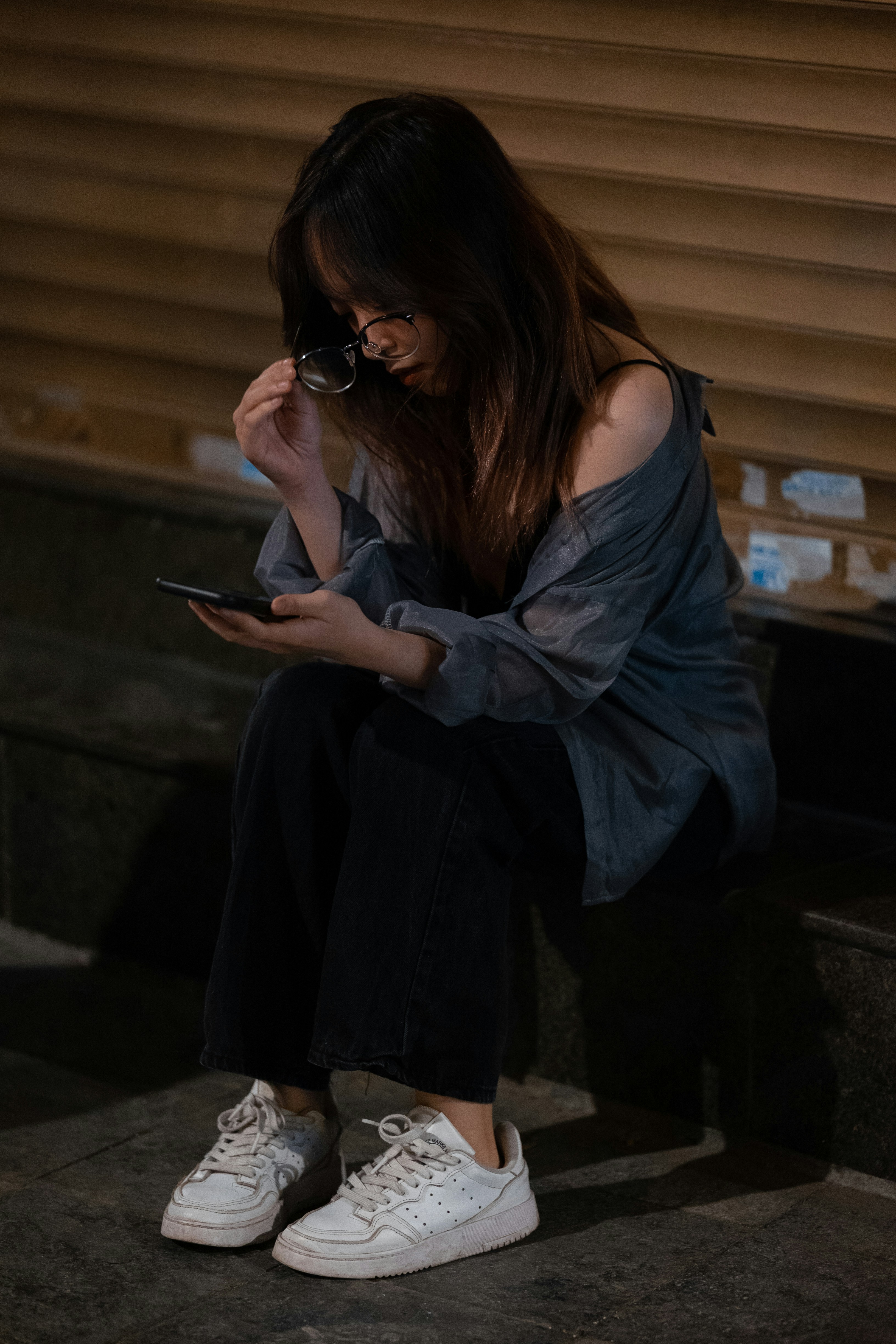 a woman sitting on steps looking at her cell phone