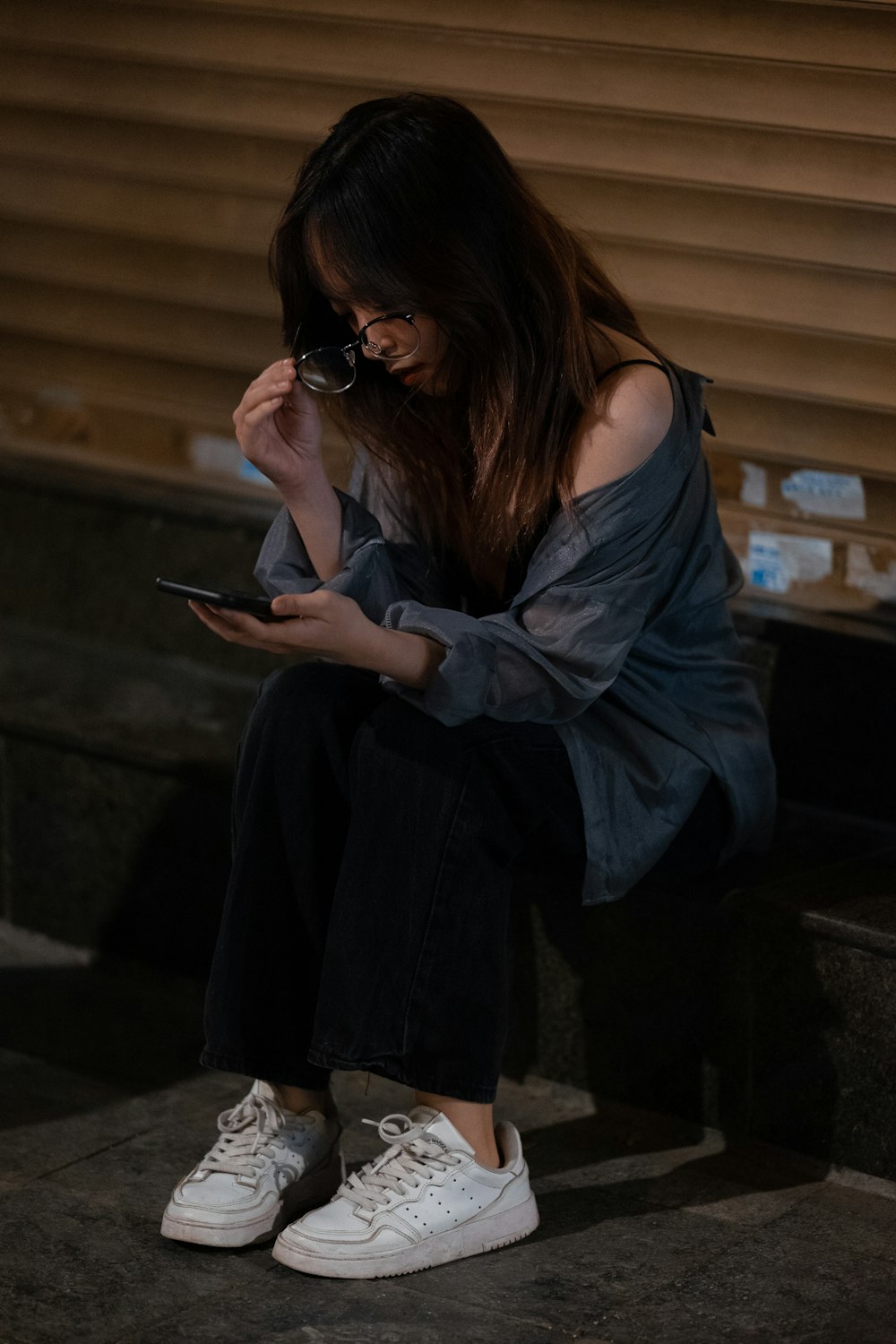 uma mulher sentada em degraus olhando para o celular