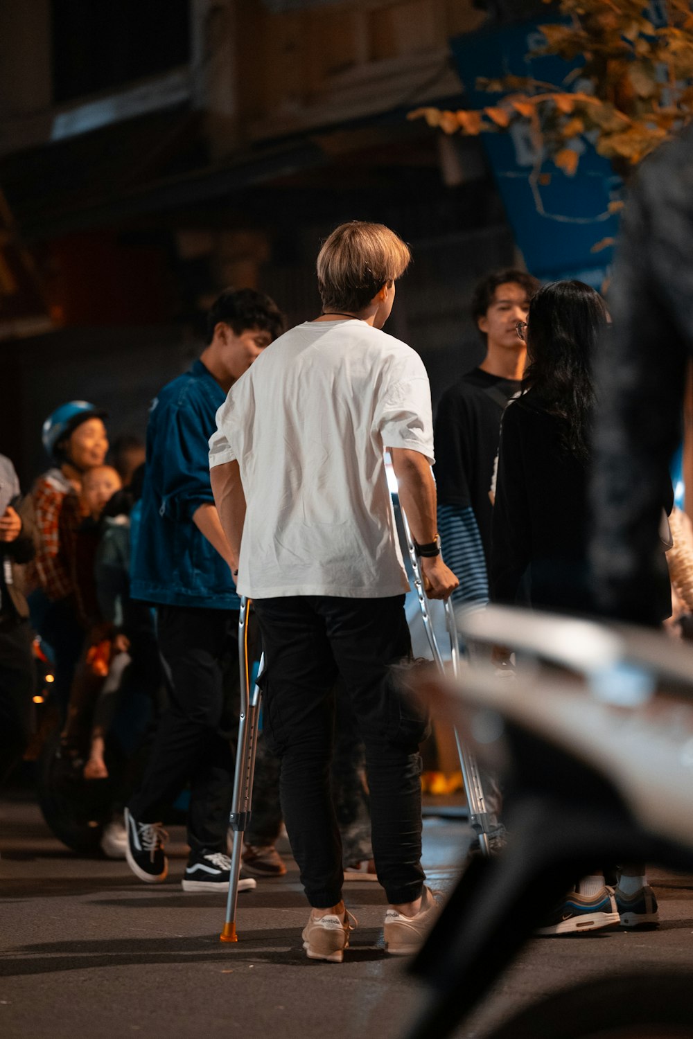 a group of people walking down a street at night