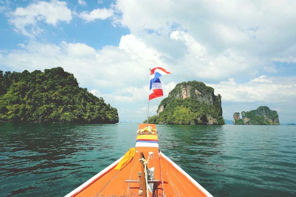 a boat with a flag on the bow in the water