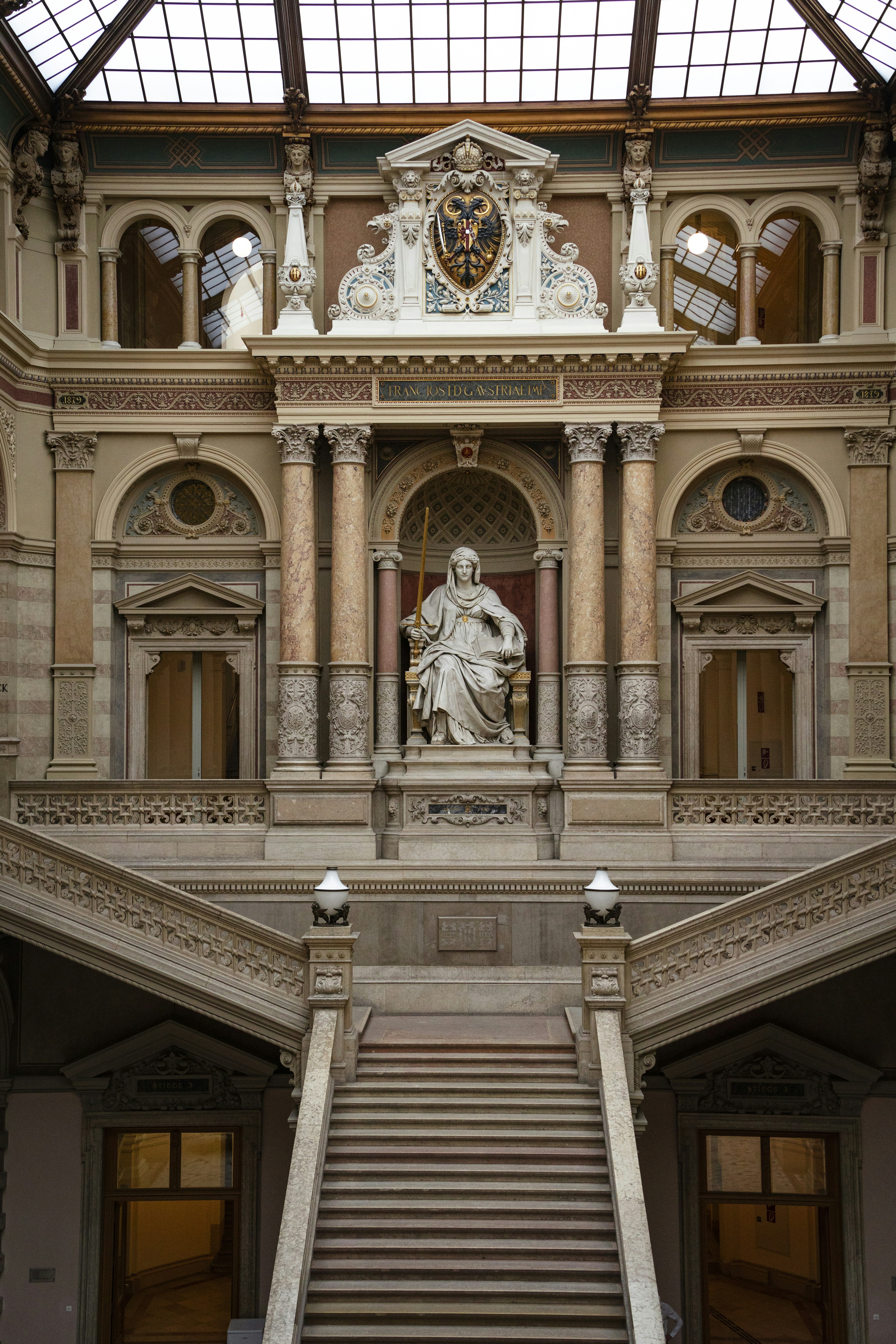 a large building with a staircase and a statue on the wall
