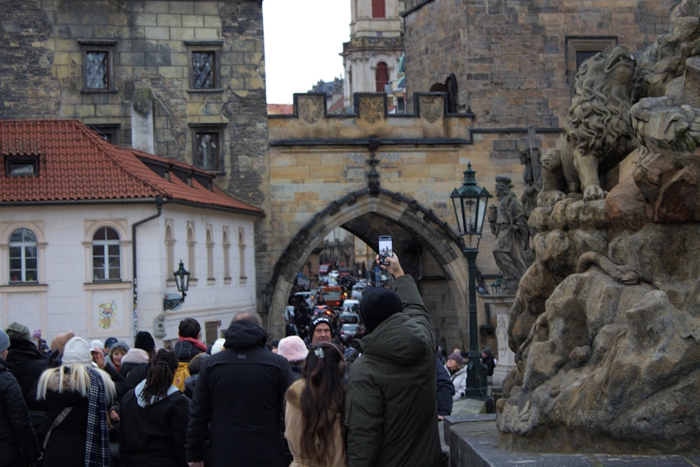 a crowd of people walking down a street next to tall buildings