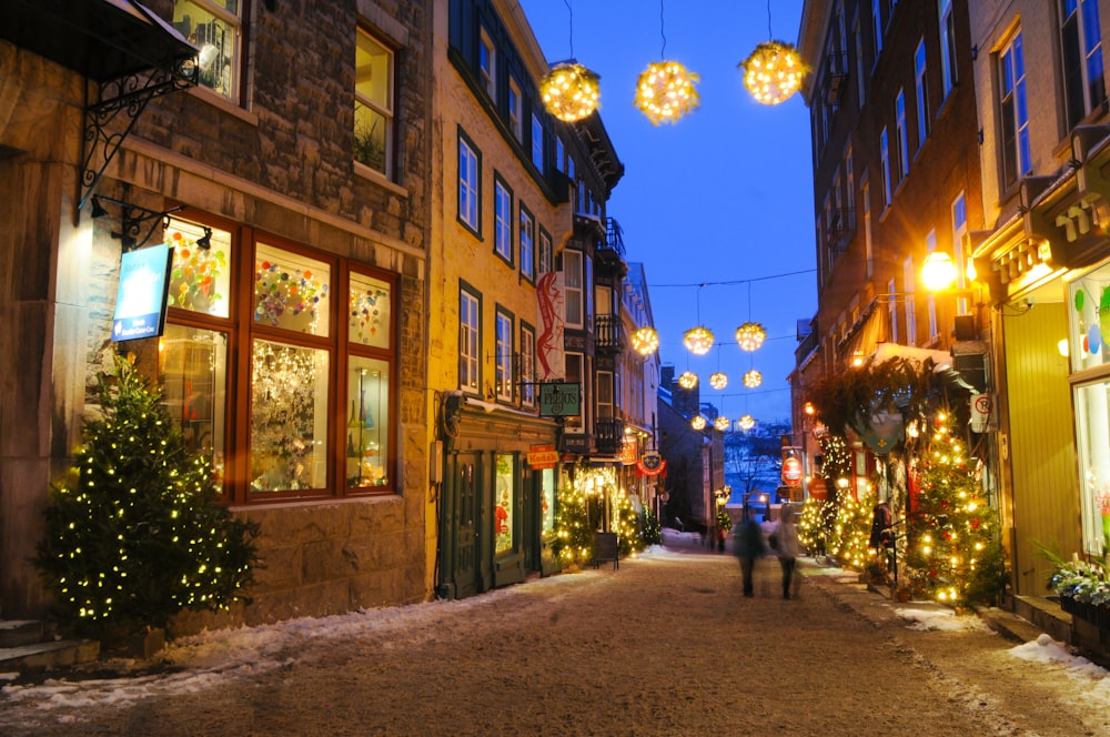 a person walking down a street with christmas lights