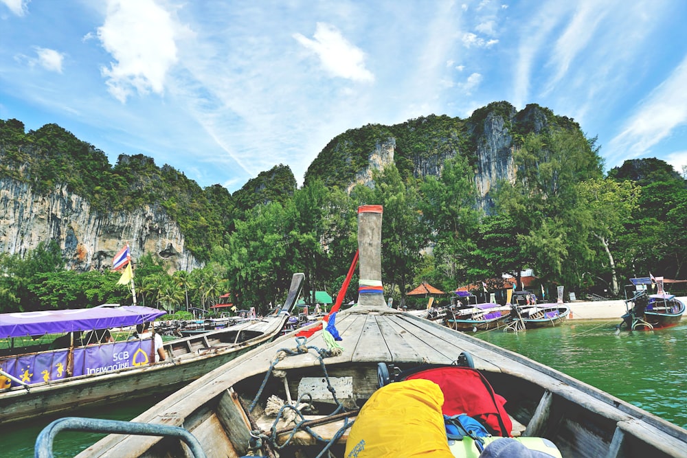 a boat is docked at the shore of a mountain lake