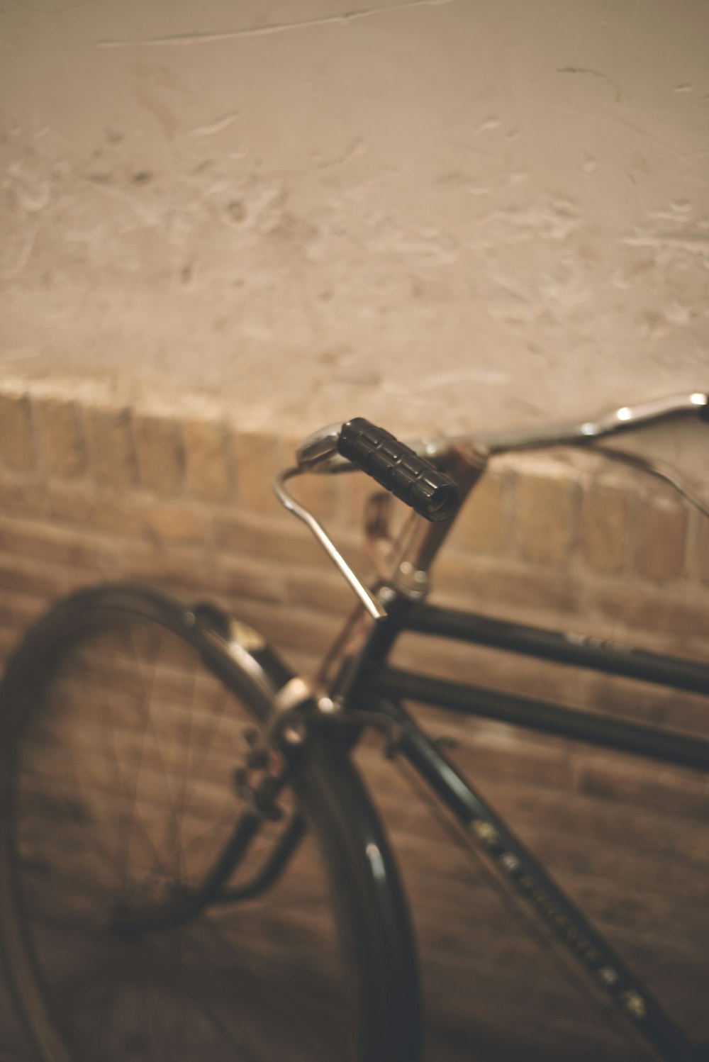 a close up of a bike parked against a brick wall