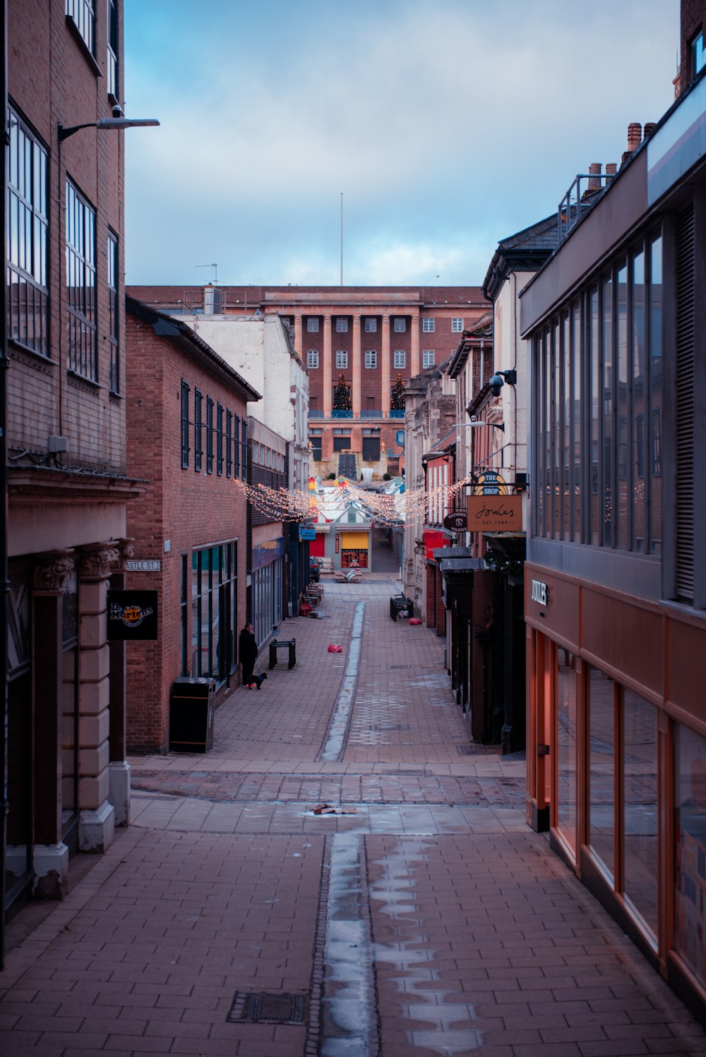 a narrow city street lined with brick buildings