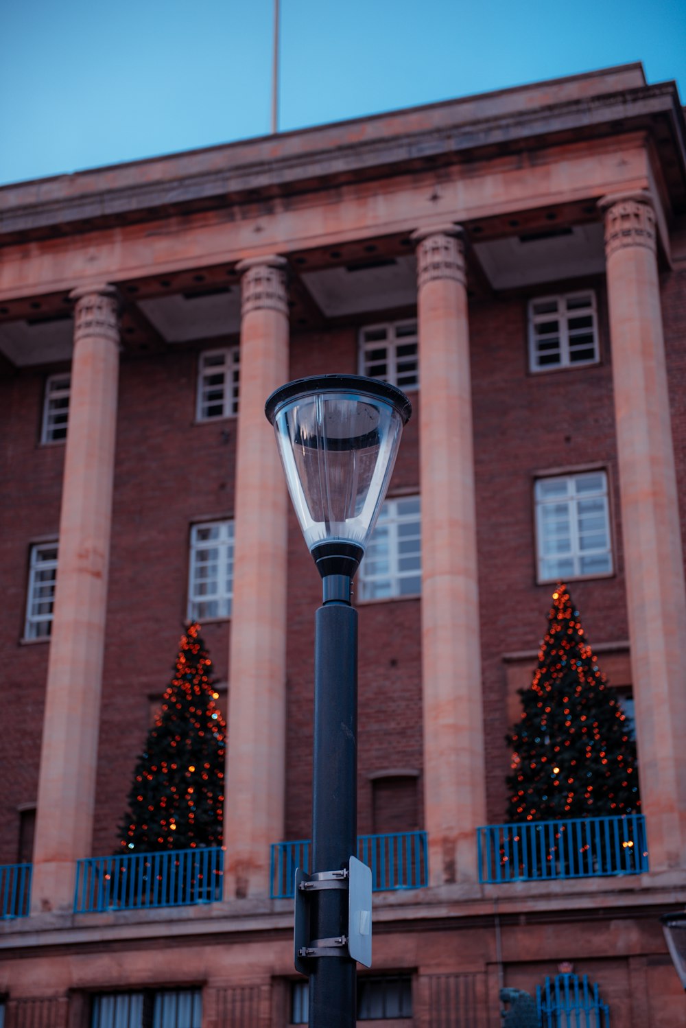 a street light in front of a building with a christmas tree