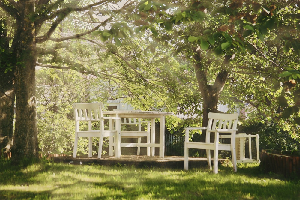 a couple of white chairs sitting on top of a lush green field