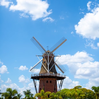 a windmill is shown against a blue sky with clouds