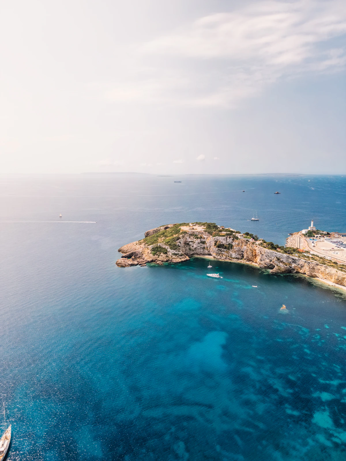 Aerial view of Cala Talamanca in Ibiza with blue Mediterranean water, shoreline, and boats