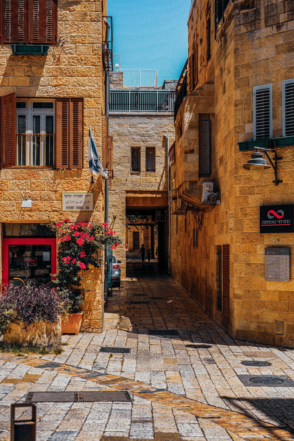 a cobblestone street lined with buildings and flowers