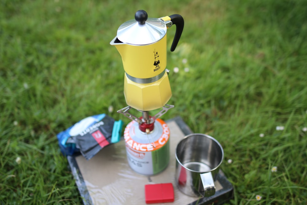 a stove top coffee maker sitting on top of a metal tray