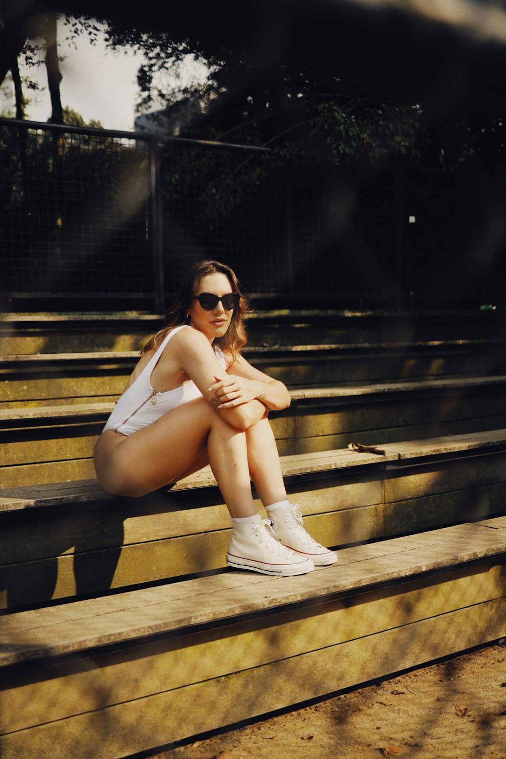 a woman sitting on a bleachers with her legs crossed