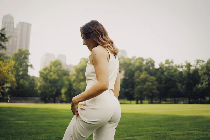 curvy woman in white jumpsuit in park