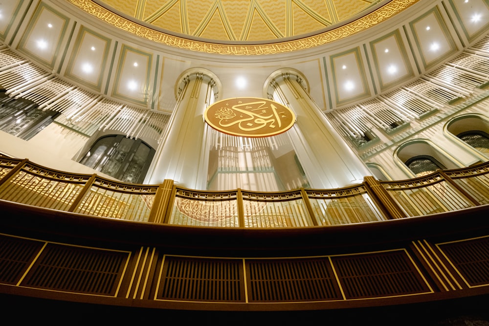 a circular building with a gold and white sign hanging from the ceiling