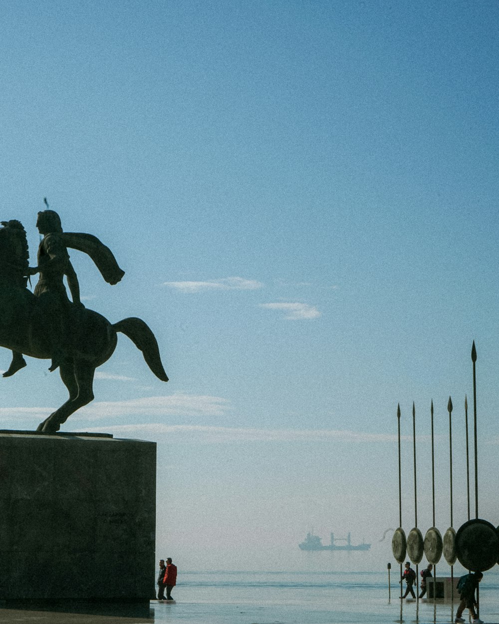 a statue of a man riding a horse next to a body of water