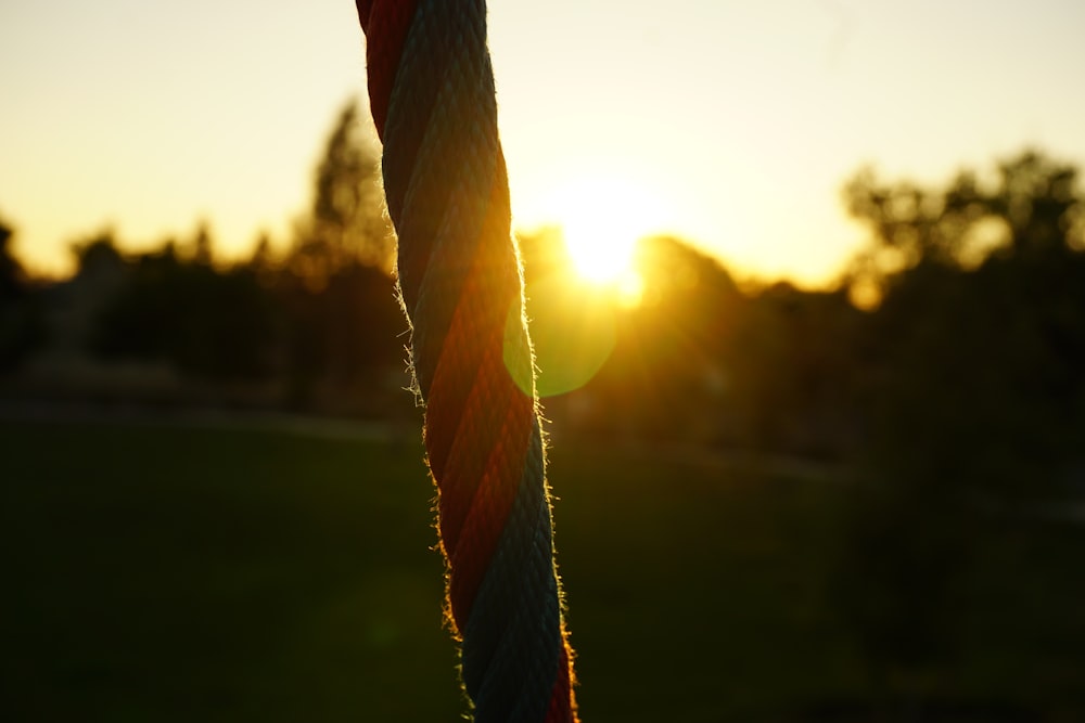a close up of a rope with the sun in the background