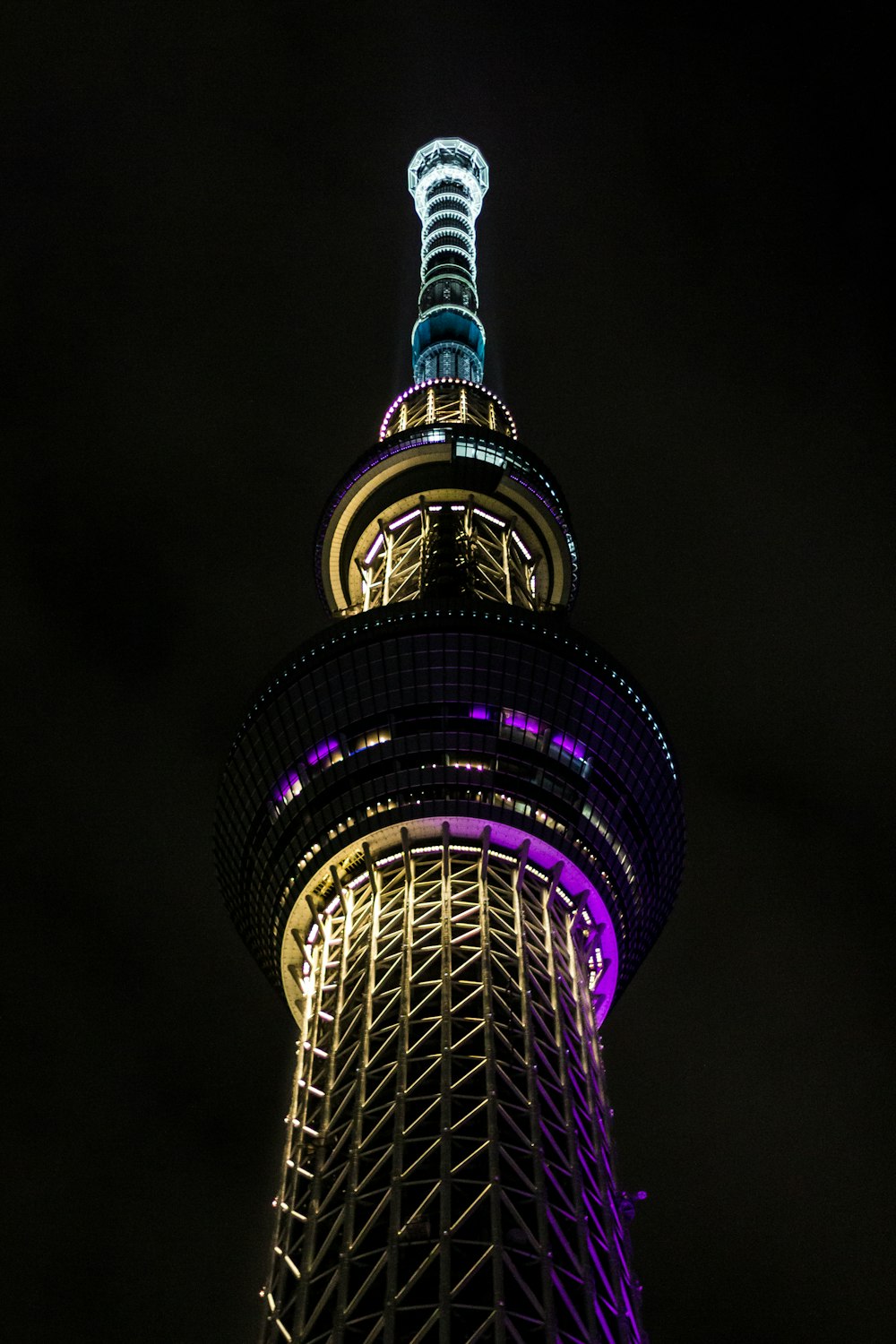 the top of a tall tower lit up at night