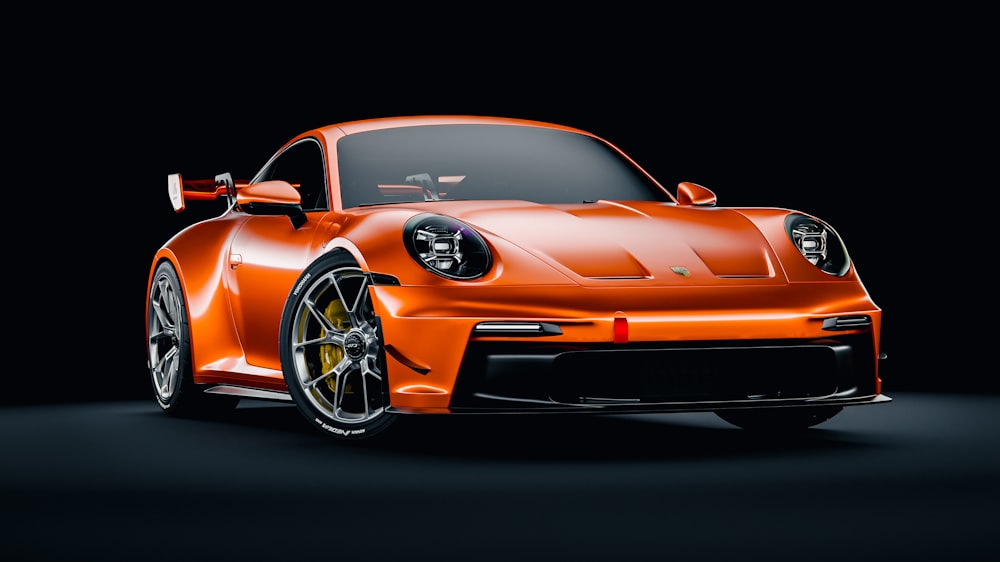 an orange sports car in a dark room