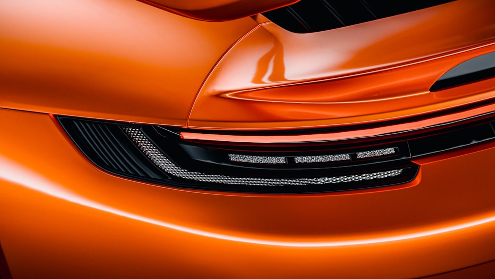 a close up of a shiny orange sports car