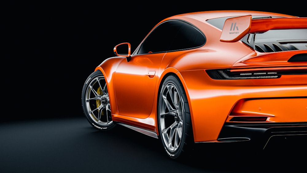 an orange sports car on a black background