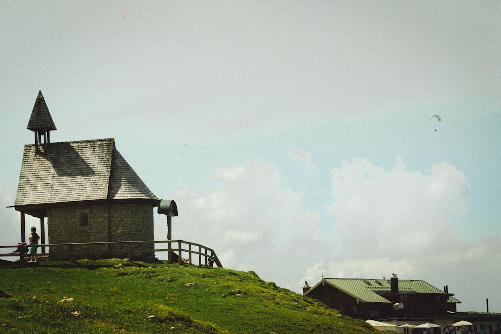 eine kleine Holzkirche auf einem grasbewachsenen Hügel