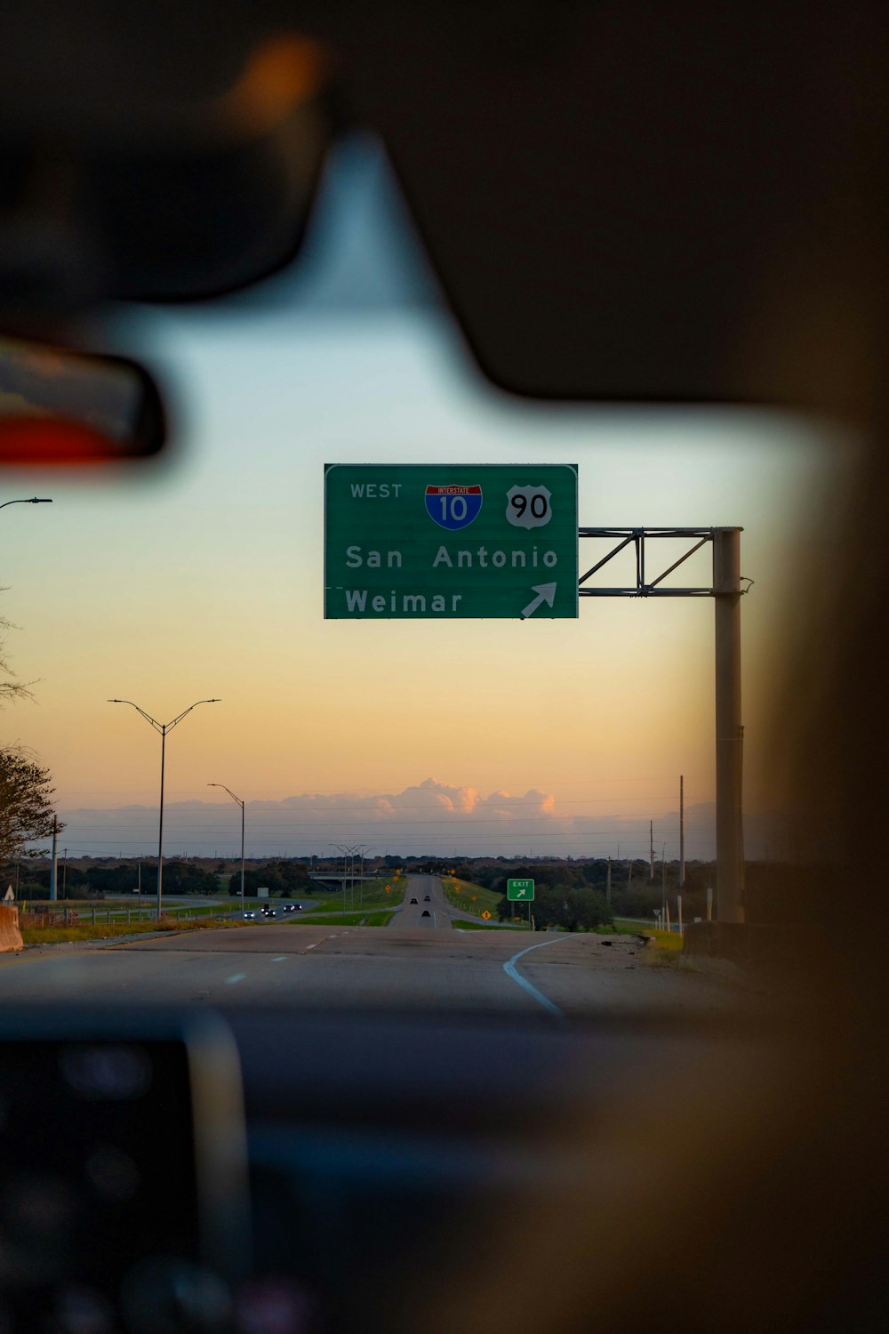 a view of a street sign from inside a car