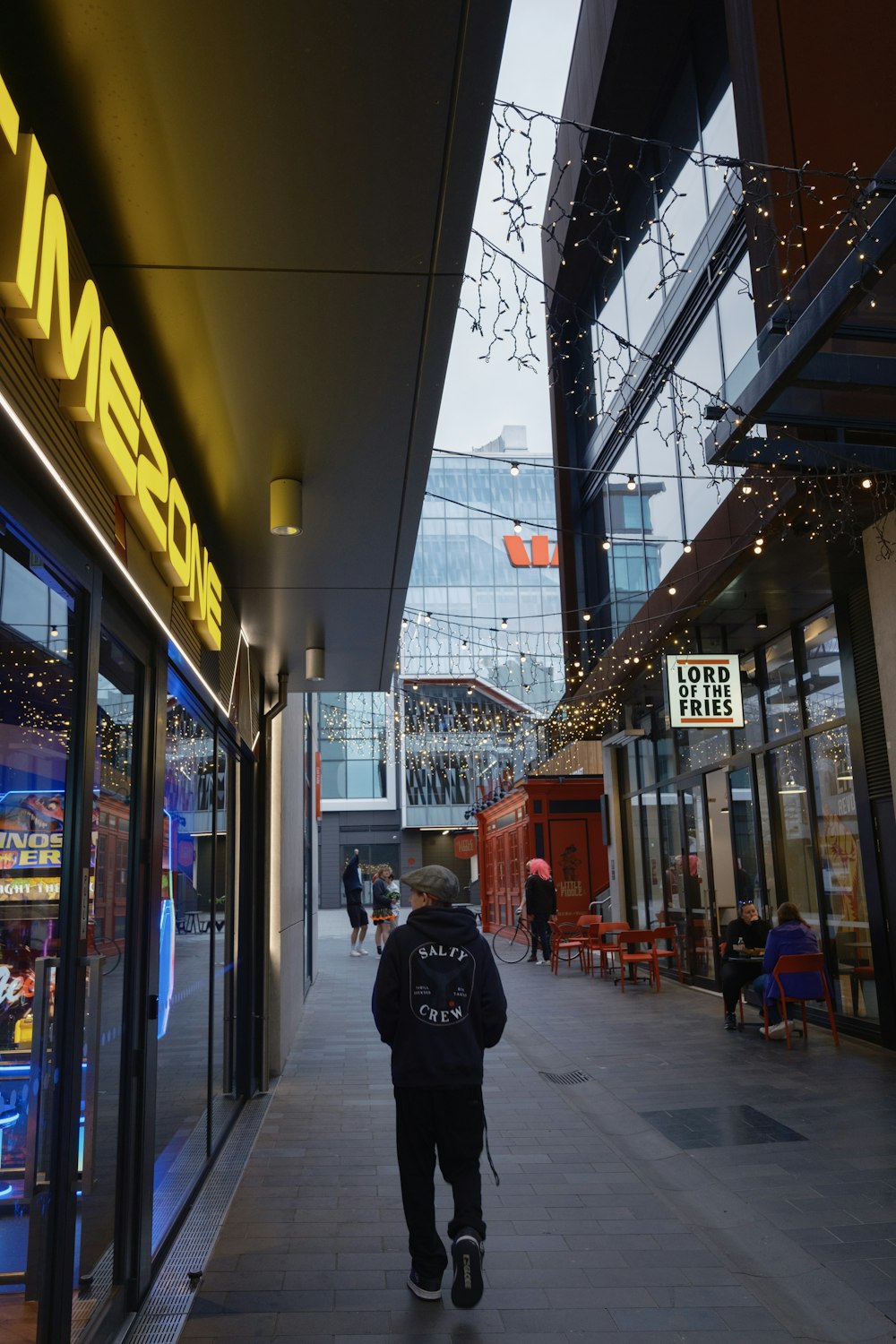 a man walking down a sidewalk next to a building