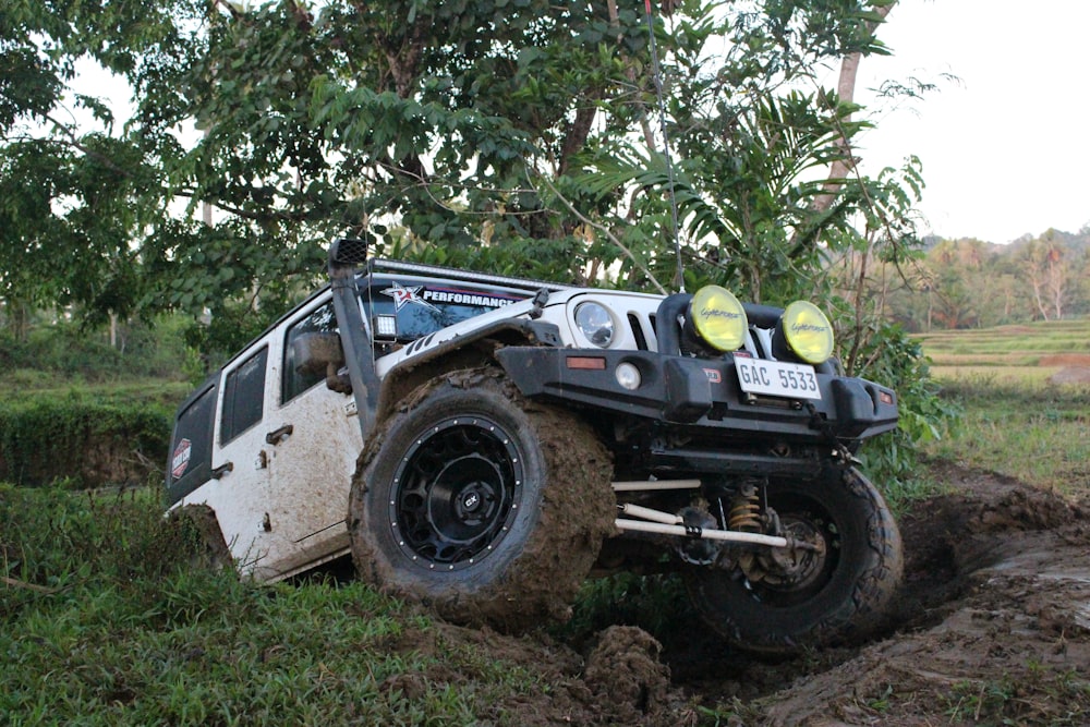 a jeep is stuck in the mud by a tree