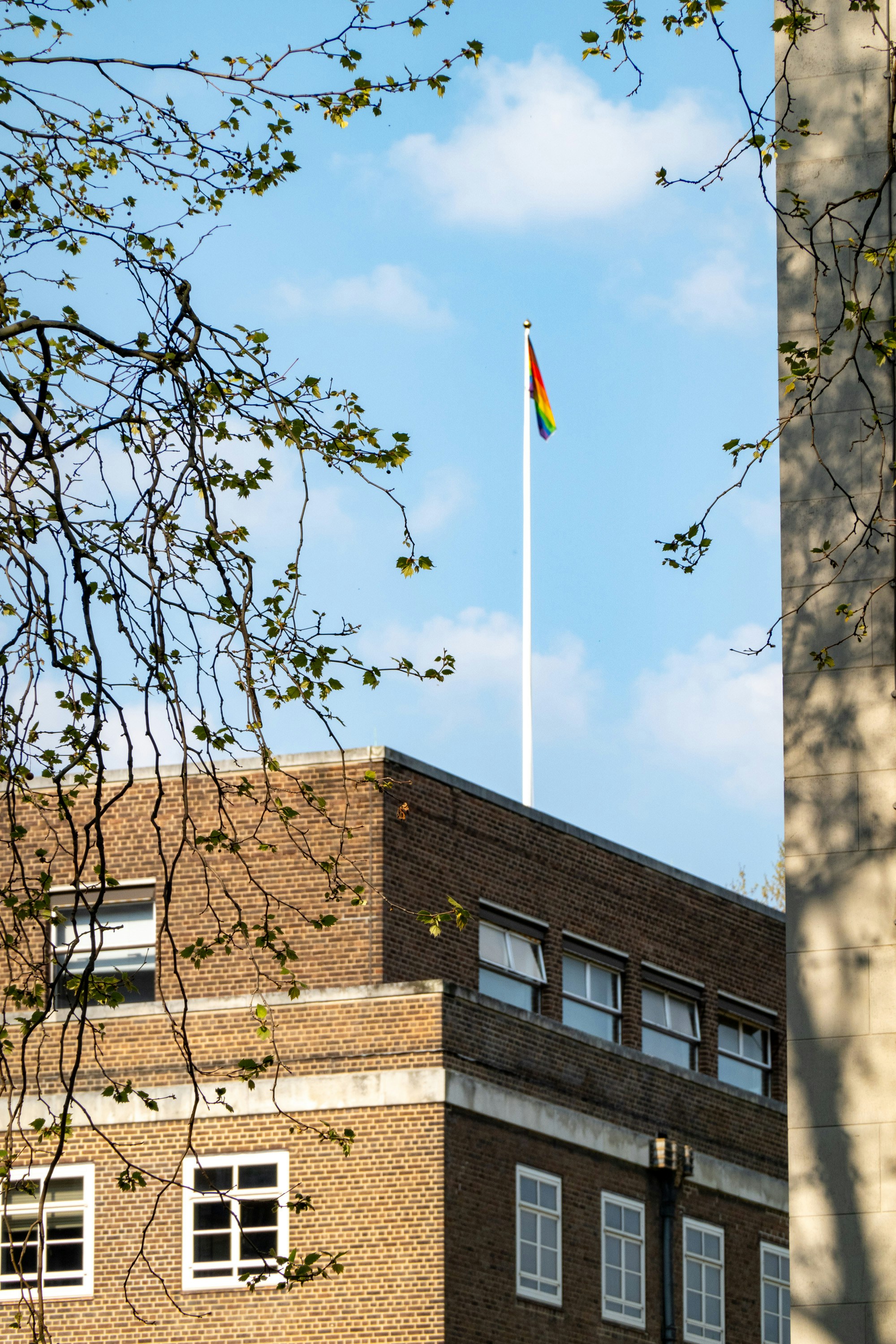 A tall building with a flag on top of it photo – Free Building Image on ...