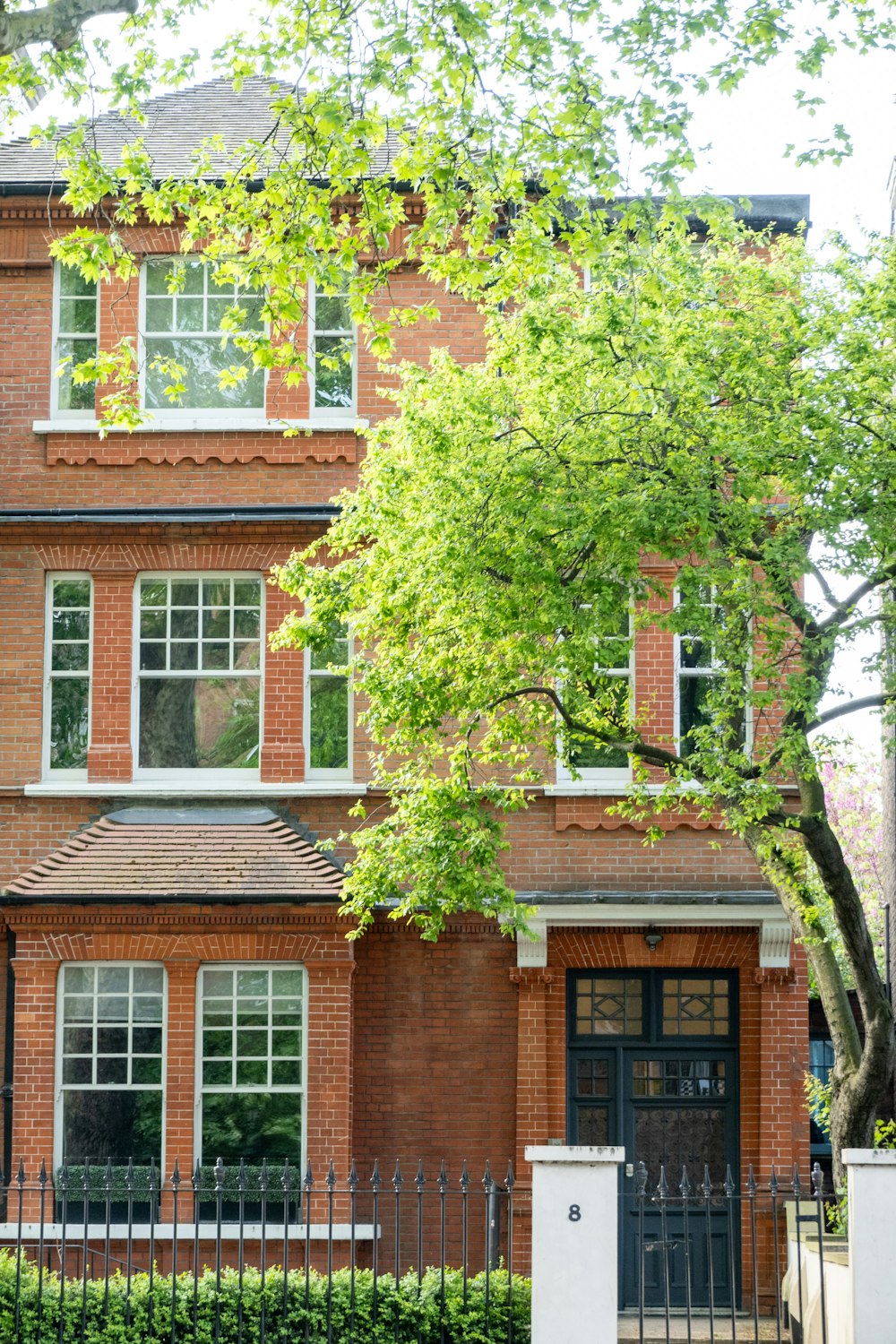 a red brick house with a black gate