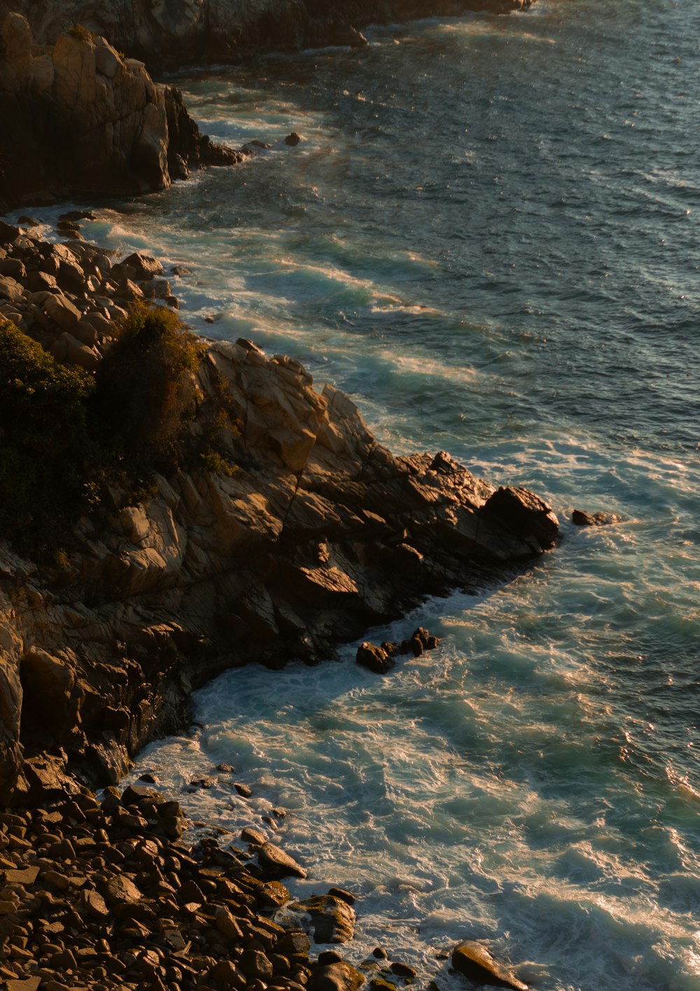 a person riding a surfboard on a rocky shore