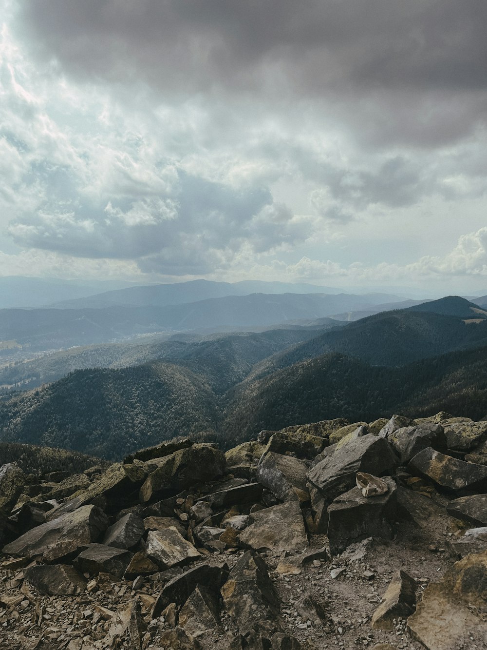 a view of a rocky mountain range under a cloudy sky