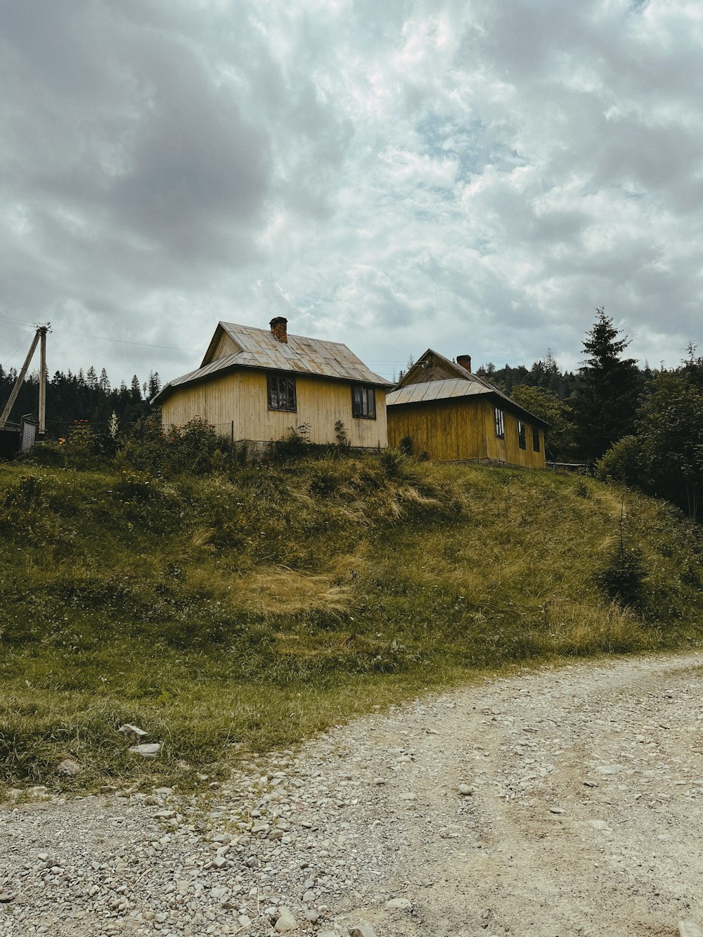 a dirt road leading to a house on a hill