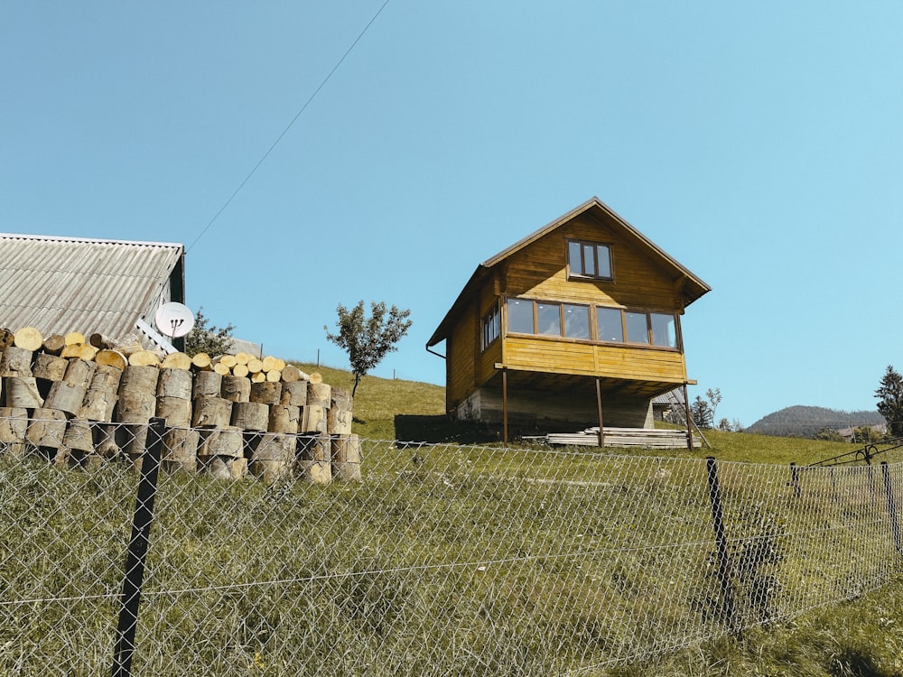 a wooden house sitting on top of a lush green hillside